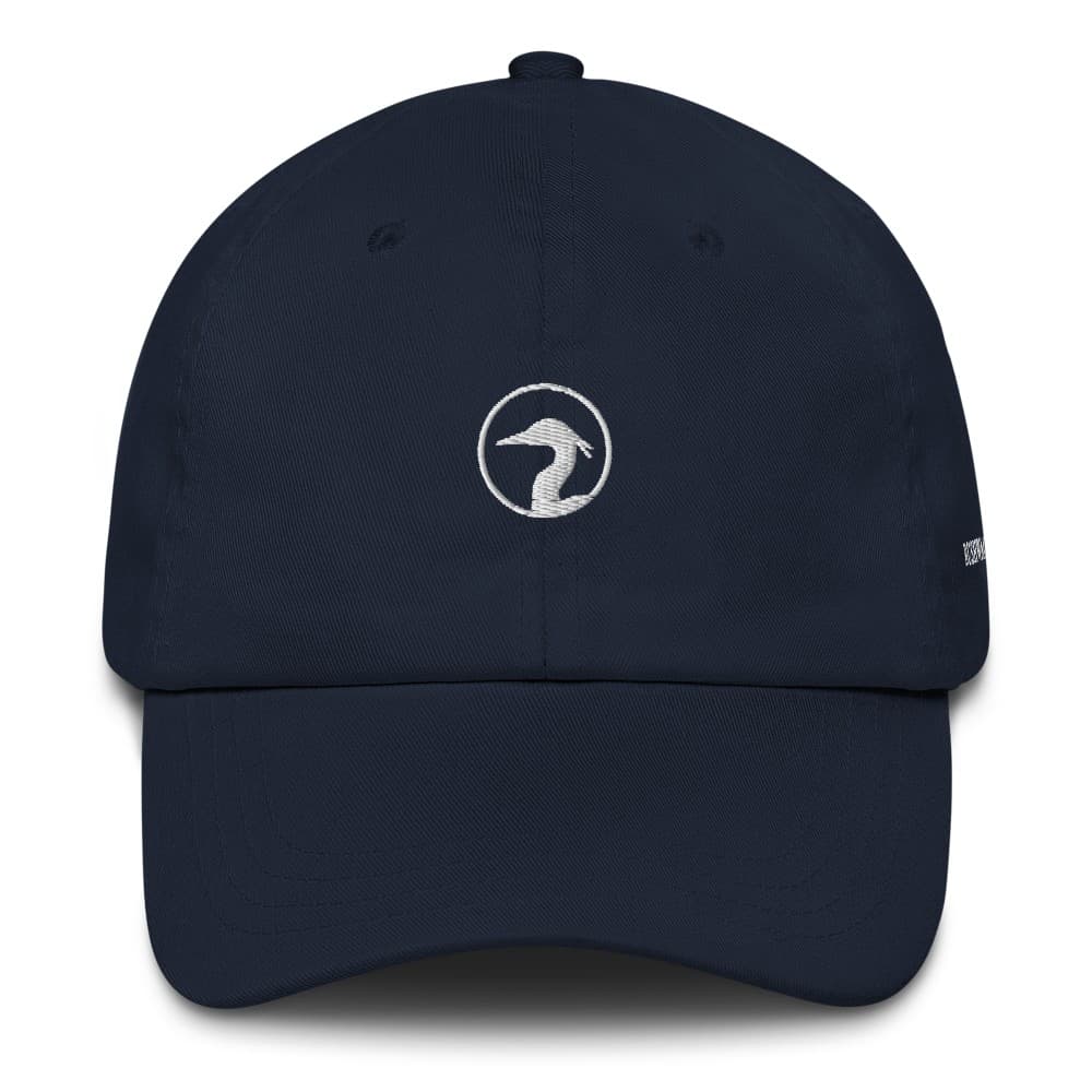 A Navy unstructured dad hat with the Bushwacker Bay heron ring embroidered in thread on the front panel
