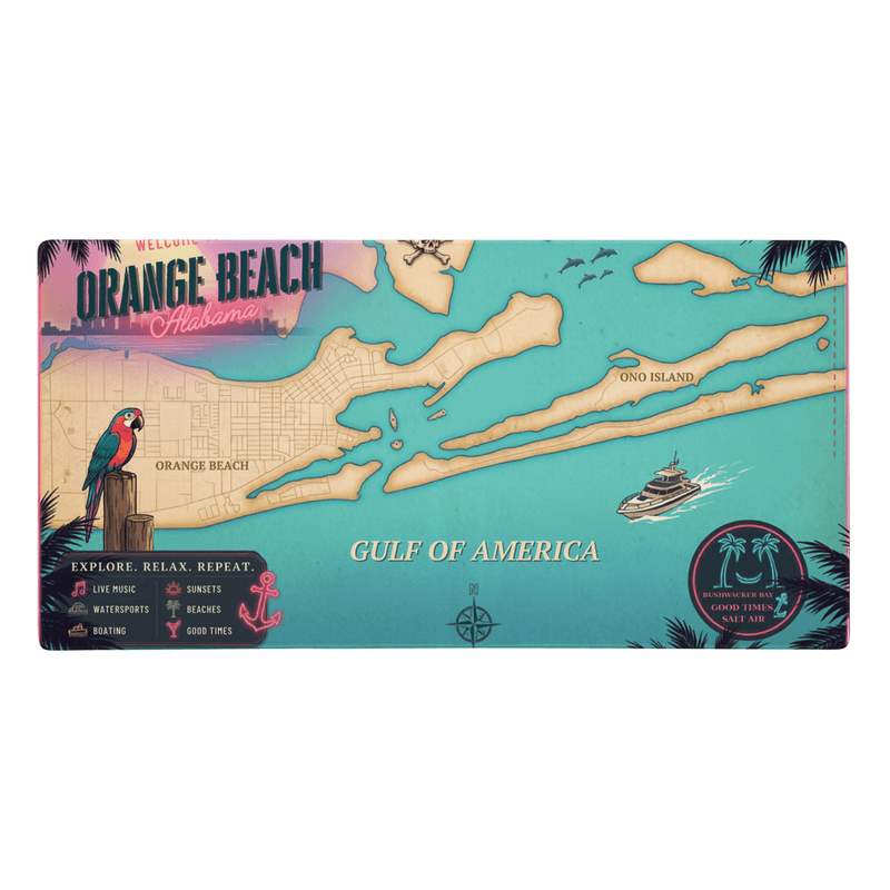 A desk mat printed edge to edge with a retro neon postcard map of Orange Beach, Alabama — turquoise water, palm silhouettes and a sunset sky