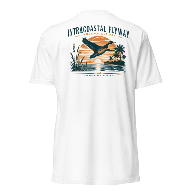 The back of a tee printed with a duck flying over a sunset bay — amber sun, palms and marsh grass, with arched Intracoastal Flyway lettering above and the Bushwacker Bay wordmark beneath